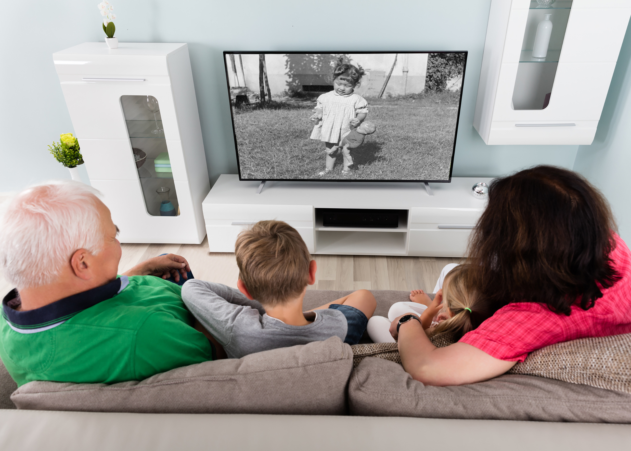 Grandparent And Grandchildren Watching Old Video Together