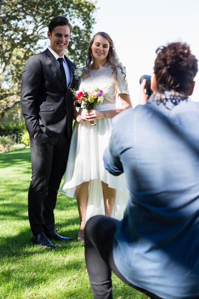 Photographer taking photo of newly married couple